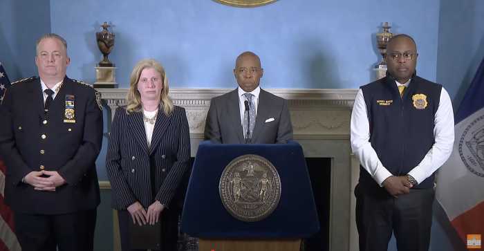 four people at a podium in NYC during press conference about immigration protests